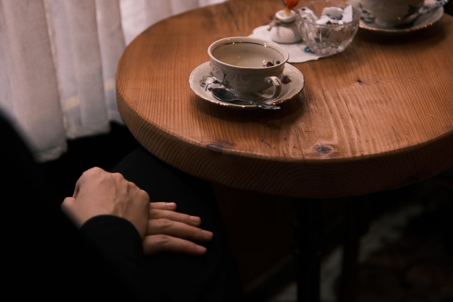 丸いテーブルでお茶を囲む落ち着いた場面